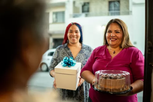 Mother and daughter arrive with cake FG Trade Latin istock